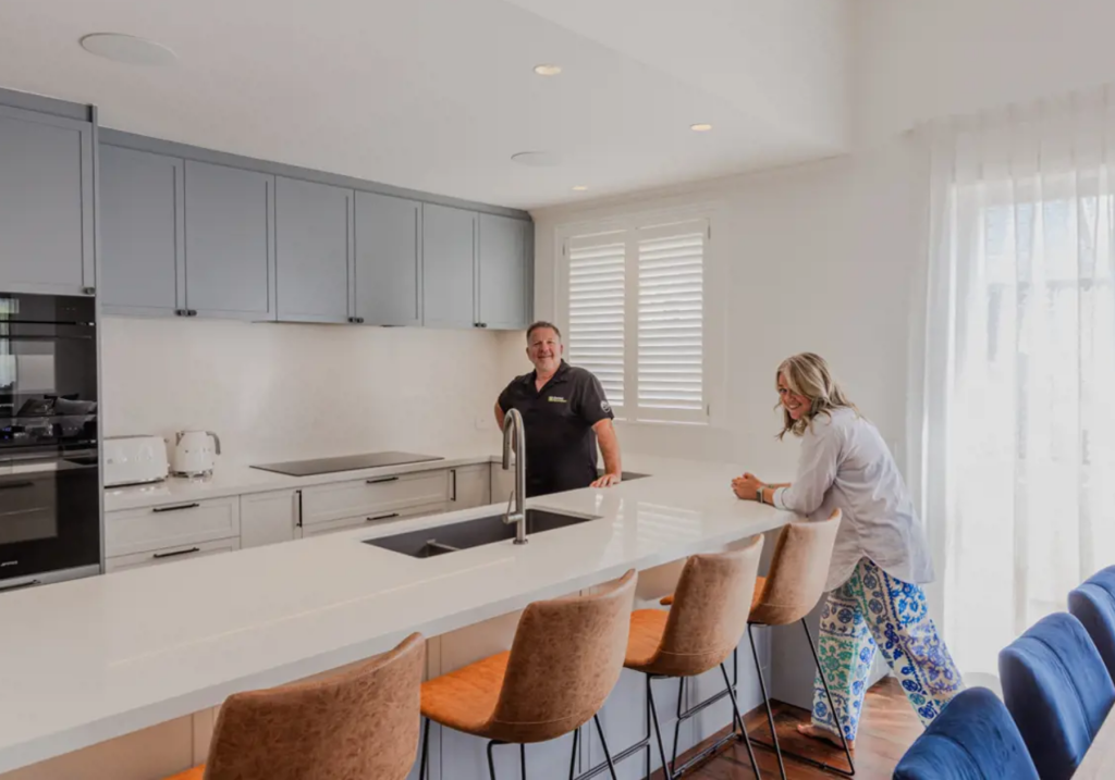 Couple reviewing renovation plans with budget notes and sketches.